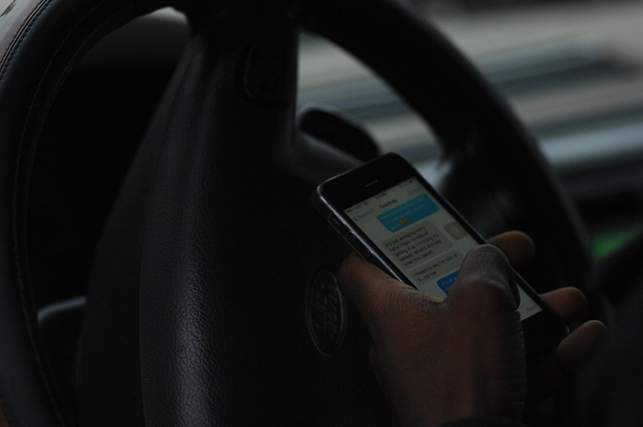 A student texts a friend while parked near the high school on Nov. 11.