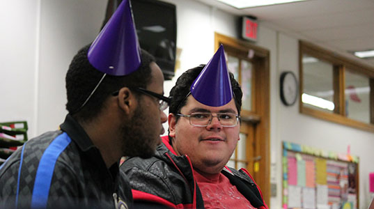 Seniors Joshua Beckles and Mauricio Rivas sport purple party hats identifying them as English teacher Valerie Doersens students during conferences in Room 109 Nov. 25. Said Rivas, If my girlfriend sees this, please dont kill me.