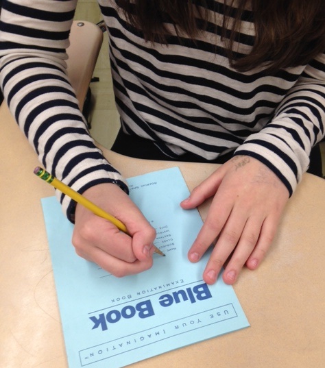 In a preview of college exam practices, students write essay responses in Blue Books. 