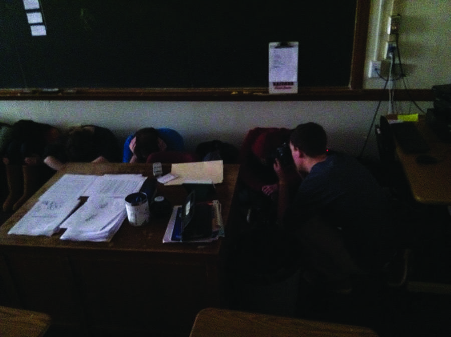 To create the cover image for this issue, Photo Editor Will McKnight photographed students who volunteered to act as if they were following lockdown procedure after school April 15 in Room 224.