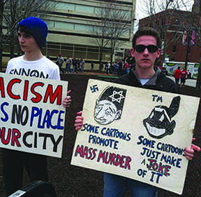 2013 Shaker graduates Jack Nemeth and Andrew Rossman hold posters at the annual Chief Wahoo protest. Protesters compared the Chief Wahoo logo to any other bigoted mascot, saying that it promotes racist values and furthers disrespect of Native cultures. “I went there [to the protest] because I wanted to show my disapproval because we had the Holocaust, and [our] people were dehumanized by these caricatures,” said Nemeth. “And this propaganda and this Chief Wahoo is the same thing because in America we took their land--[the land of] people who didnt really have choice of us coming there.”