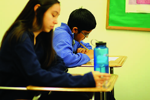 Sophomore Advanced Placement United States History students Caitlin Culina and Gautam Apte take a quiz Dec. 8. Students who take classes such as these can confront several tests or quizzes on the same day despite the high school’s testing schedule policy. 