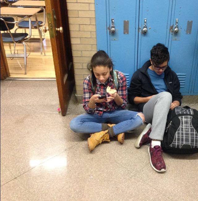 Students engage with their phones while they wait for their first period class to begin Dec. 16.