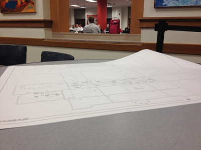 A blueprint of the high school lies unfurled on a cafeteria table