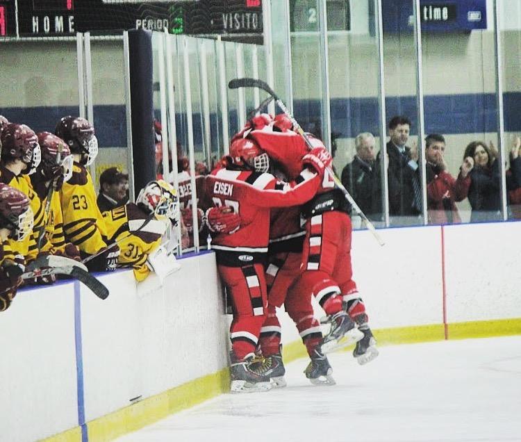 Raider hockey players celebrate after senior Peter Shick ties the game with a third period goal against Walsh Jesuit in the District Semi Final last Tuesday. The Raiders will play US tonight in the District Final. 