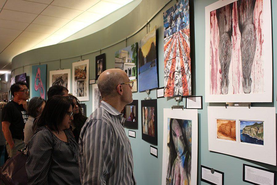 Attendees view student artwork at the annual Art Exposed art show on the second floor of the Shaker Heights Public Library on Lee Road May 6. 