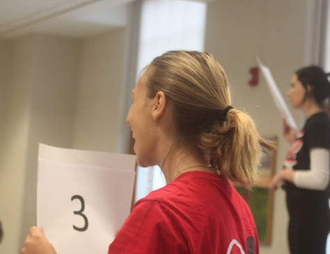 Core leader Nadia DeGeorgia holds up her group number while waiting for participants to join.