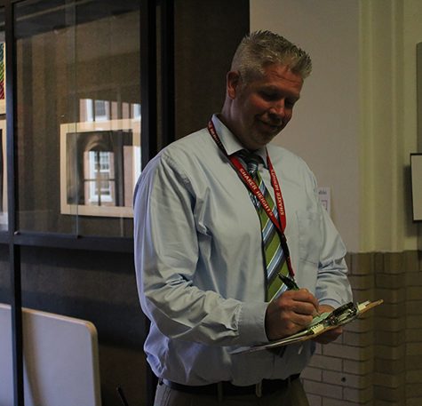 Dean of Students Greg Zannelli writes a tardy pass for a late student. Tardiness is a tier-one discipline offence punishable by detention or Saturday school. Tier one discipline also includes dress code and cell phone violations.