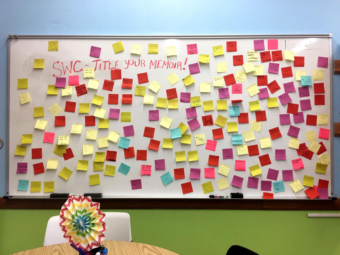 Students post sticky notes of their memoir titles on a wall in the Writing Center in Room 228 Sept. 26 during second period.