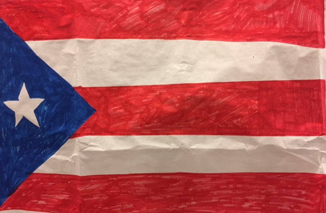 A Mano en Mano poster of the Puerto Rican flag on display in the upper cafeteria.