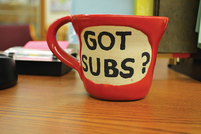 A mug sits on the desk of Administrative Assistant Gloria Cottingham, who plays a large role in coordinating substitutes for the high school.