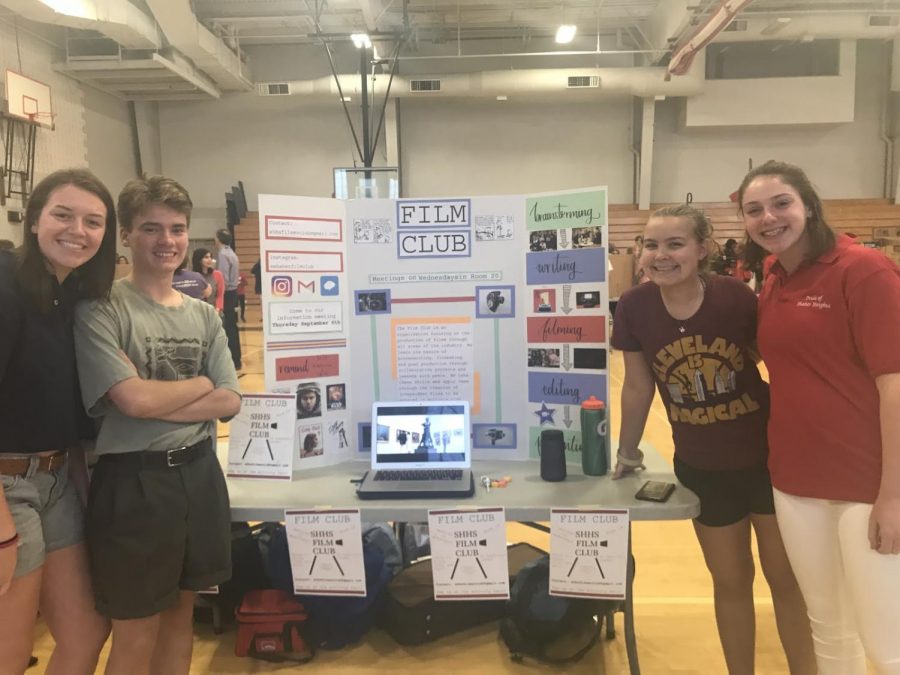 Executive Film Club team members Emie Coffman, Clovis Westlund, Rebecca Rhodes and Zoe Rosenfelt stand by their table at the activity fair.