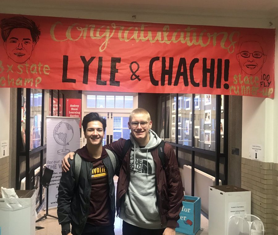 Senior Lyle Yost, who won his third consecutive state diving competition, and senior Charlie Gustafson, state runner-up in the 100-meter butterfly, smile in front of a congratulatory poster.