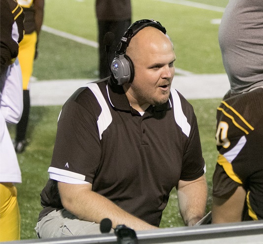 Former Brush assistant  and current Shaker head coach Alex Nicholson addresses his players on the sideline during a Brush football game.