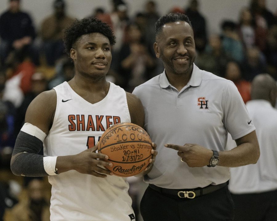 Senior Dakota Cochran and varsity basketball coach Danny Young celebrate Cochrans achievement of reaching 1,000 career points.