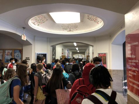 Students walk through a crowded hallway where masks will no longer be required starting March 1