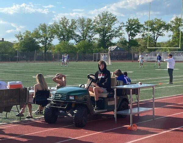 Student Intern Henry Sheperd assists with a Girls Lacrosse game on the sideline