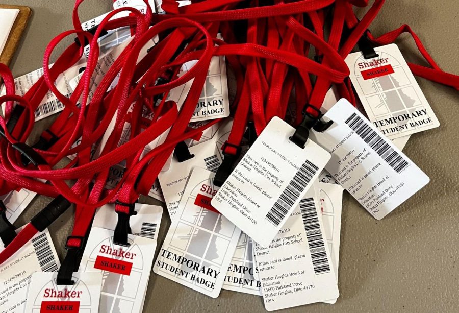 A pile of temporary student ID cards on red lanyards on a grey table