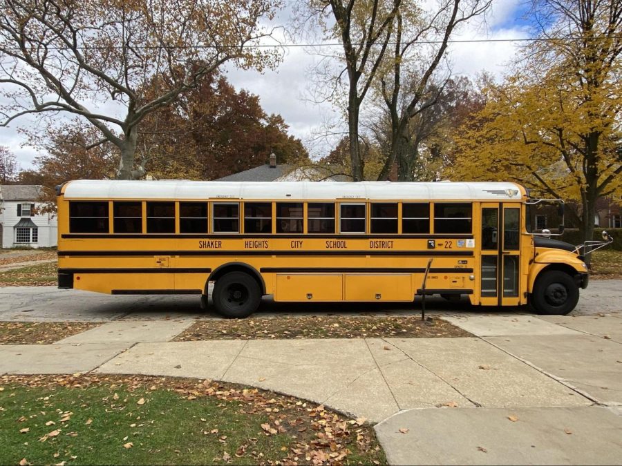 A yellow school bus parked outside the high school