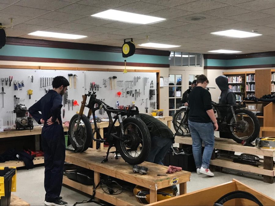 Three motorcycles in an area of the high school library converted into a workshop