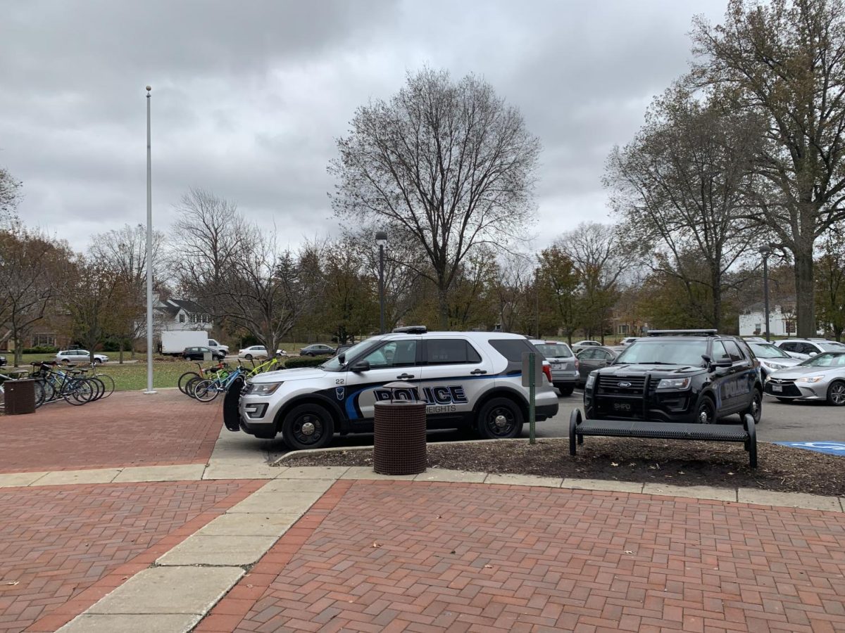 Two police cars parked outside of the high school front entrance in November 2019. File Photo.