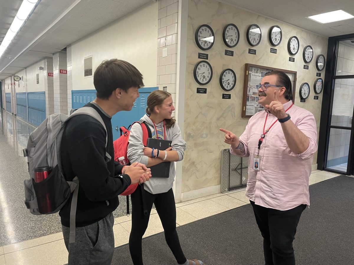 Michael Better, a junior, and freshman Natalie Better enjoy a conversation with substitute teacher Spencer Sowards near the high school main entrance May 29. Natalie said Sowards often asks her about her sport, figure skating. 