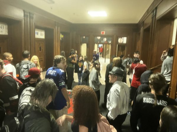 Students enter the large auditorium lobby after administrators admitted them back into the building to escape the rain.