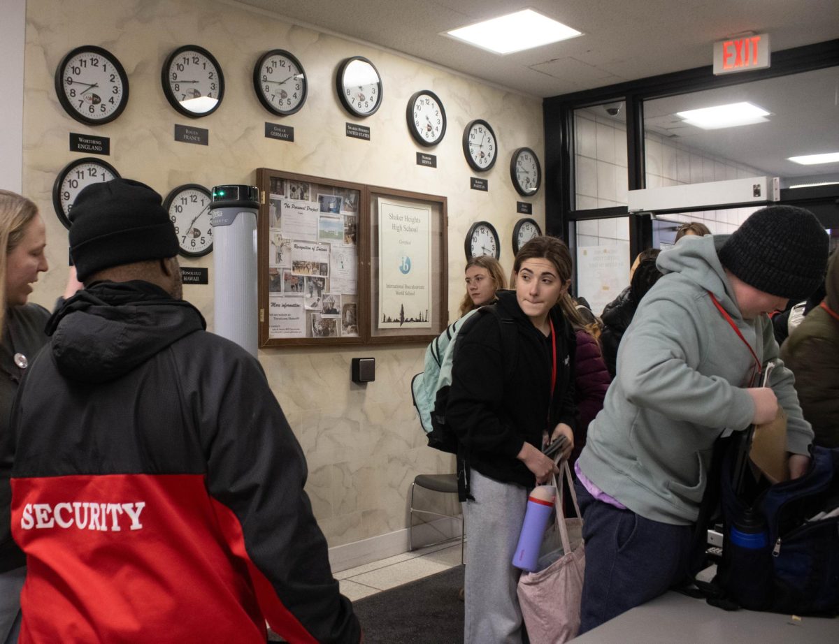 Freshman Nora Novak awaits a chance to set aside objects known to trigger the system before proceeding through screening in the main entrance Jan. 23. 