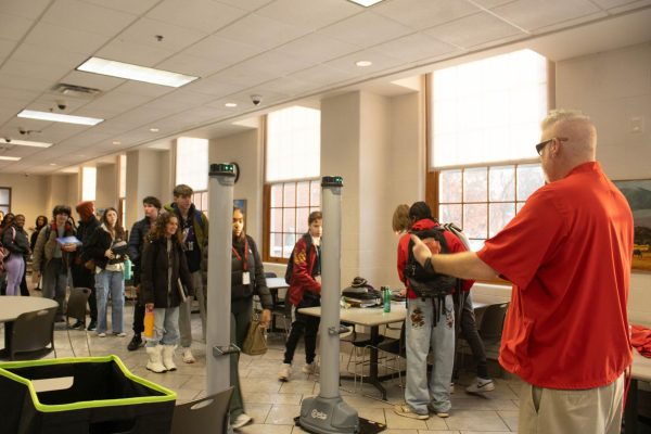 Dean of Students Greg Zannelli motions students through one of two OpenGate weapon-detection units in place in the lower cafeteria Jan. 23. 