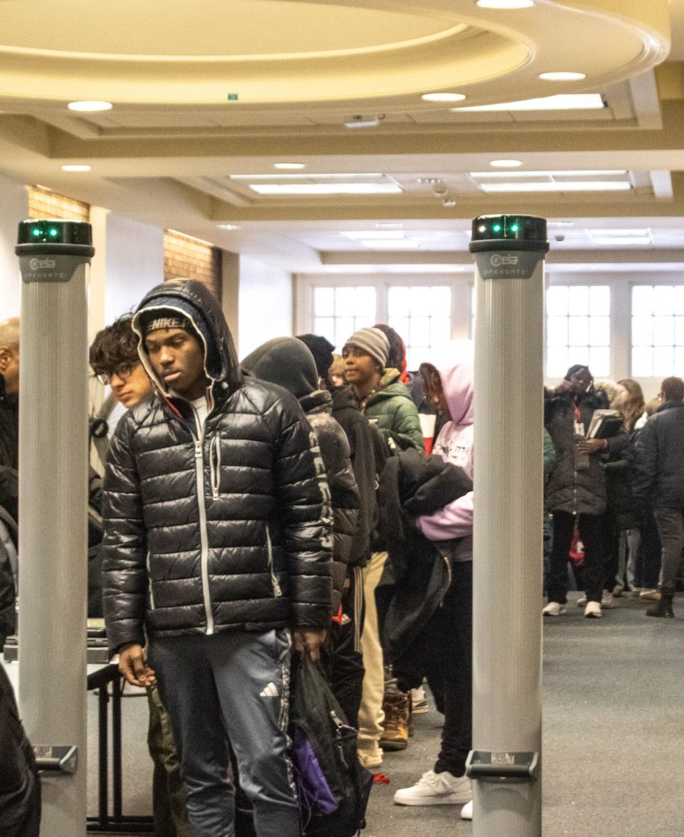 A student at the head of the line awaits a turn to pass through the OpenGate weapons-detection system in the high school egress Jan. 23. Students entered the high school through the egress, front entrance or lower cafeteria, where systems were in place for the first time today. 