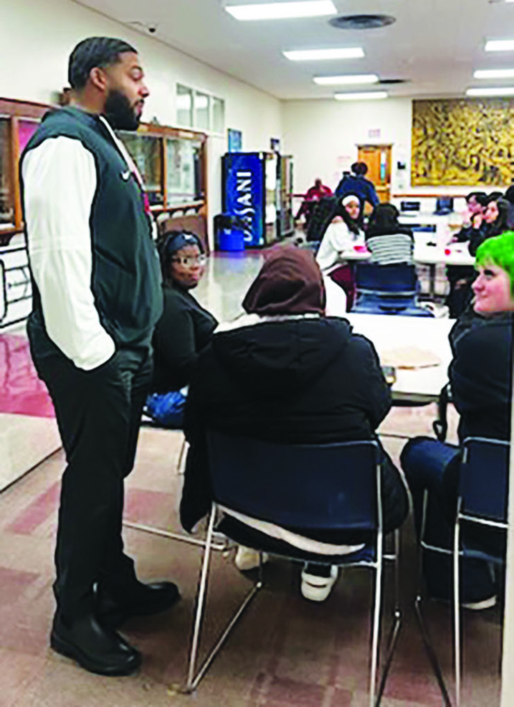 Isaiah Wyatt speaks with junior Za'Nyah Williams, junior Deborah Butler and senior Mia Barefoot in the senior lounge of the cafeteria Jan 17. Wyatt, former assistant principal of the Innovative Center for Personalized Learning, has promoted collaboration and transparency in his new role as interim principal of the high school.