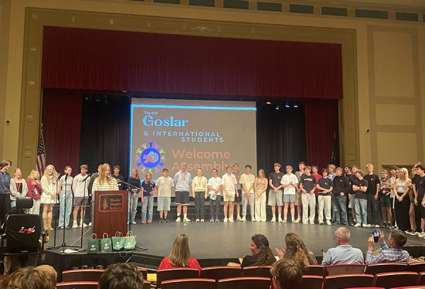 Senior Julienne Avril introduces each host student and their exchange student at the introduction assembly in the large auditorium Oct. 3.