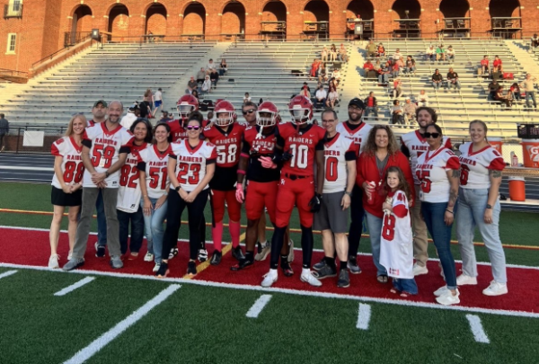 Teachers chosen by senior football players to be honored for Faculty/Staff Appreciation Night pose with senior football captains Kingston Seals, Isaac Smith, James Wood and Jacire Eaddy before the opening coin toss on Oct. 3 at Russel H. Rupp Field.
