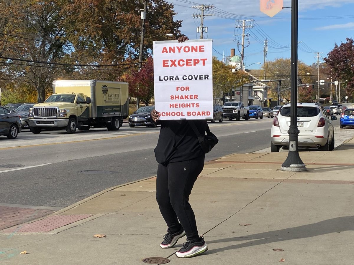 April, who did not want to be identified by last name, displays her anti-incumbent message on Lee Road today. A Shaker parent, she supports Issue 51, the operating levy, and said new leaders are necessary to address test scores, budgeting and special education.