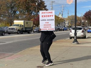 April, who did not want to be identified by last name, displays her anti-incumbent message on Lee Road today. A Shaker parent, she supports Issue 51, the operating levy, and said new leaders are necessary to address test scores, budgeting and special education.