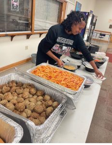 Parent Ramona Lowery prepares the pasta buffet for the football team Oct. 24 in the senior lounge.