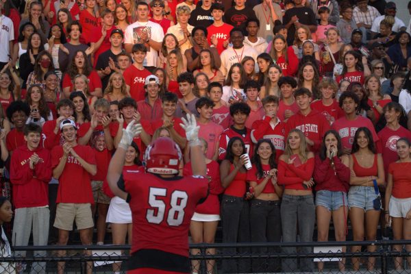 Senior offensive lineman Isaac Smith encourages the student section at Russell H. Rupp Field Aug. 22.