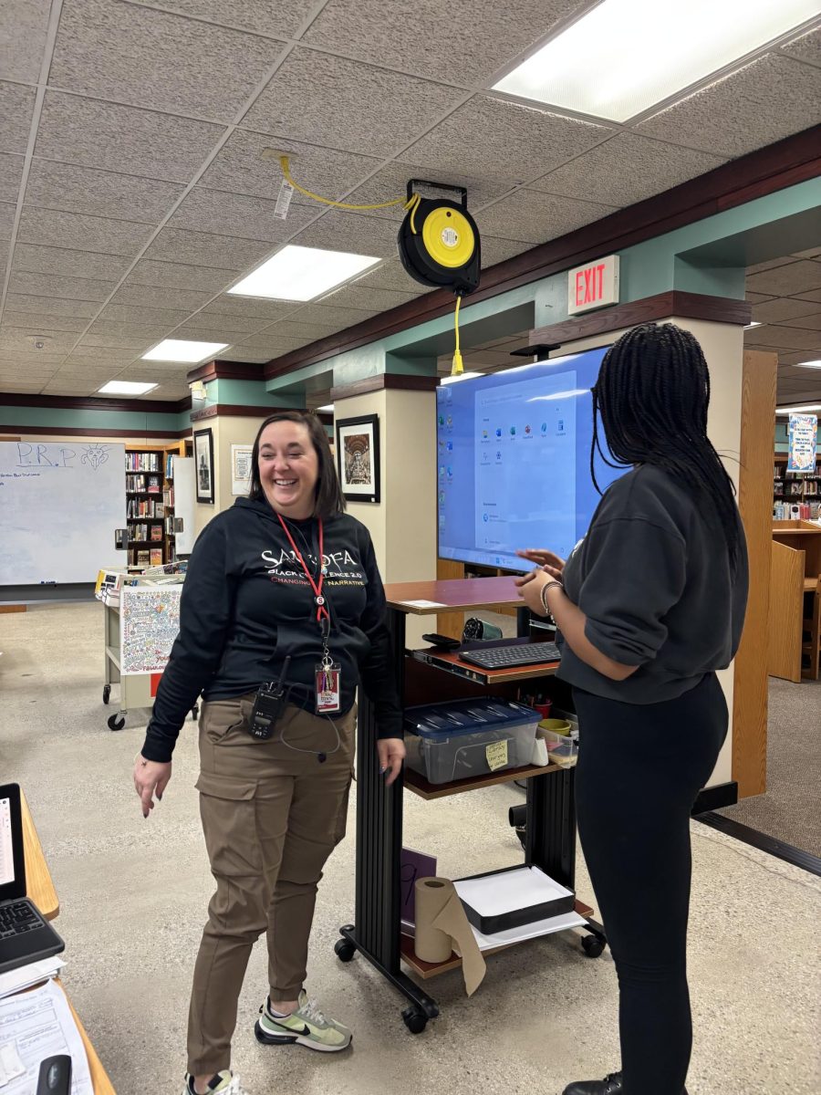 Slifkin speaks to a student in the library during ninth period Dec. 8.