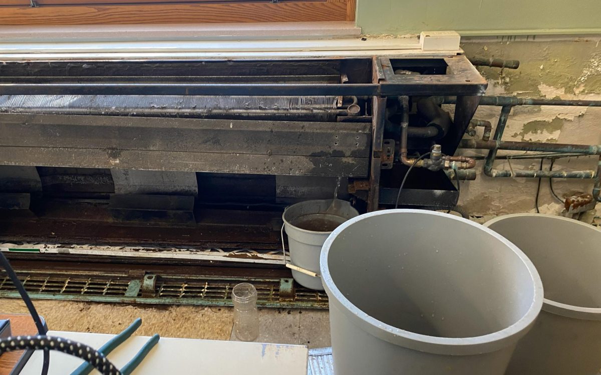 The dismantled heating unit in Room 163 drains into a bucket today after rupturing and releasing hot liquid that created steam when it met ice that had formed inside of it.  The steam triggered a fire alarm and evacuation. Classrooms in the high school's front hallway have been without heat this week, a problem that has persisted for years. 