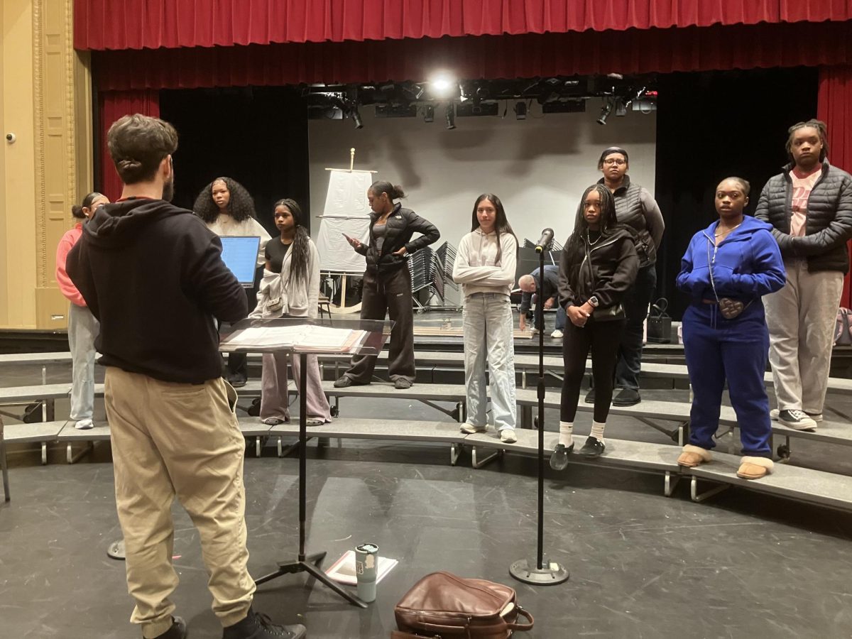 Students and Choir teacher Nicholas LaPete rehearse on March 3rd in the large auditorium.