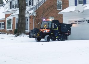 A city worker climbs back into a cart after collecting refuse at a Duffield Road residence March 17. Residents stage refuse in their driveways rather than at the curb.